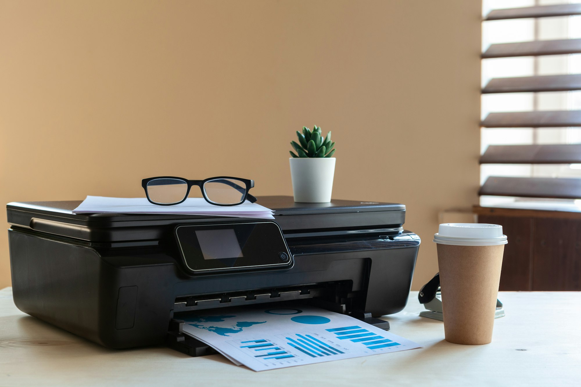 Front view of a black printer machine on a table