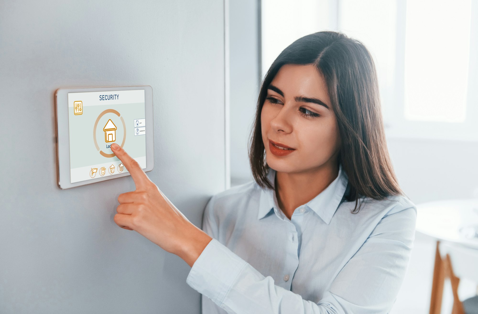 Woman is indoors controlling smart home technology